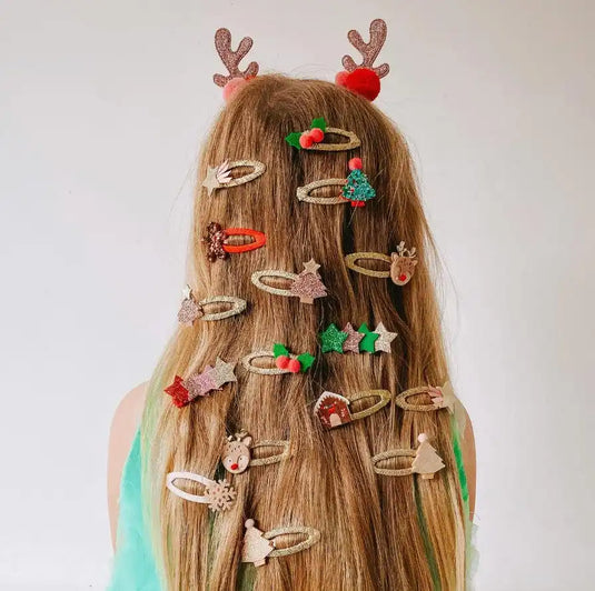Longs cheveux bruns décorés de clips de cheveux festifs et d'accessoires en forme de bois de renne.